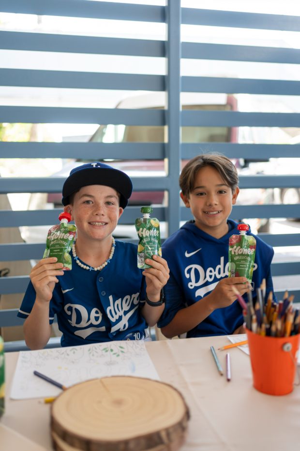 Two boys in Dodgers jerseys holding Honee pouches