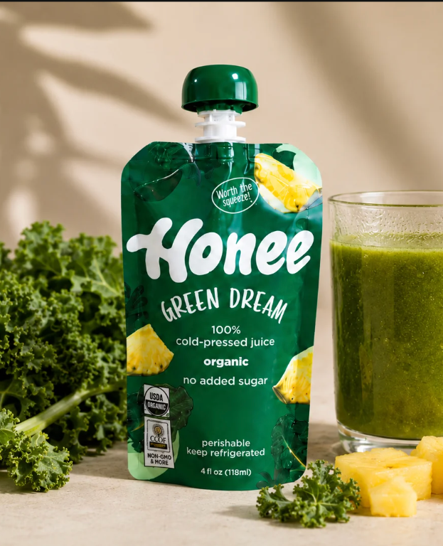 Honee Green Dream pouch with fresh fruit and a glass of juice